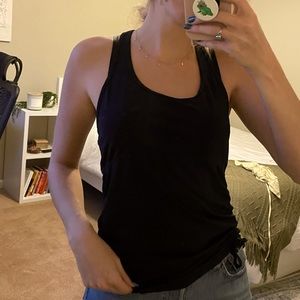 Black Fabletics workout tank with touching drawstring on front side bottom